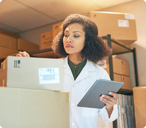 Person in lab coat with boxes