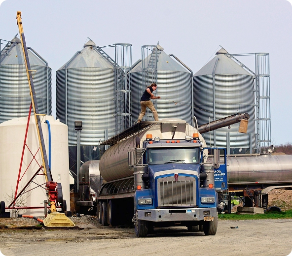 Worker on truck near silos