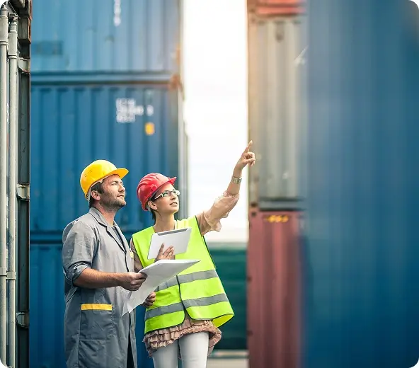 Workers inspecting shipping containers together.